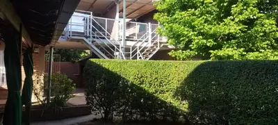 a hedge in front of a building with a staircase at Los 5 de Brochero in Mina Clavero