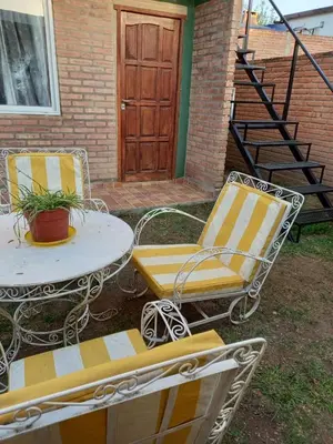 two chairs and a table and a table and a door at Departamento Estela Marys in Mina Clavero