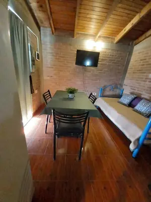 a room with a bed and a table and a bed and a bed at Departamento Estela Marys in Mina Clavero