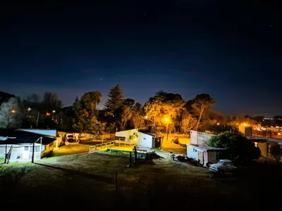 a group of buildings at night with lights at Cabañas Buen Ayre in Villa Rumipal