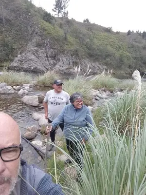 a man and a woman standing in a stream at Cabañas Buen Ayre in Villa Rumipal