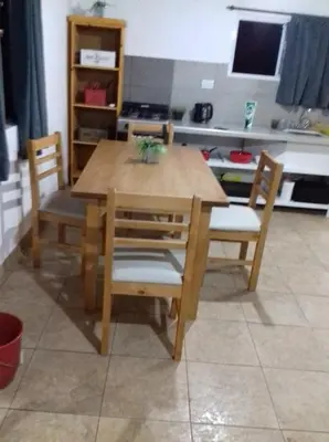 a wooden table and chairs in a kitchen at Cabañas Buen Ayre in Villa Rumipal