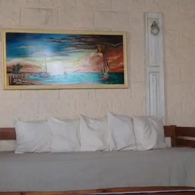 a white couch with a painting on the wall at Talita Cumi in Villa Santa Cruz del Lago