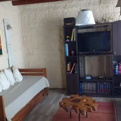 a bedroom with a bed and a tv and a table at Talita Cumi in Villa Santa Cruz del Lago