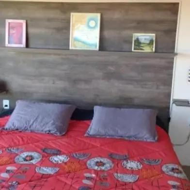a bedroom with a red bed with a wooden headboard at Talita Cumi in Villa Santa Cruz del Lago