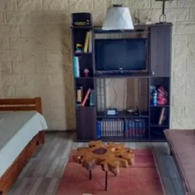 a living room with a table and a tv at Talita Cumi in Villa Santa Cruz del Lago