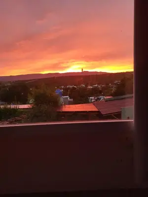 a sunset view from the window of a building at Talita Cumi in Villa Santa Cruz del Lago