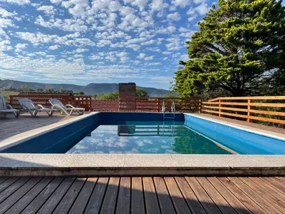 a swimming pool on a deck with a wooden deck at Casa El Descanso in San Antonio de Arredondo
