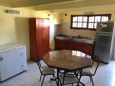 a kitchen with a table and a refrigerator at Casa El Descanso in San Antonio de Arredondo