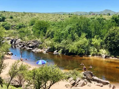 a group of people in a river with an umbrella at Casa El Descanso in San Antonio de Arredondo