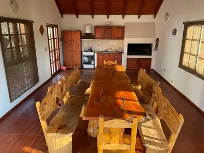 a large wooden table in a room with a kitchen at Casa El Descanso in San Antonio de Arredondo