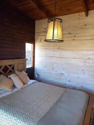 a bedroom with a bed in a wooden wall at Cabaña de Campo - Valle de Calamuchita - Sierras de Córdoba in San Clemente
