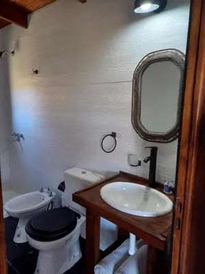 a bathroom with a toilet and a sink and a mirror at Cabaña de Campo - Valle de Calamuchita - Sierras de Córdoba in San Clemente