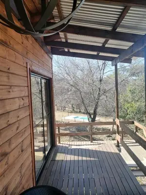 a view from the inside of a cabin with a deck at Cabaña de Campo - Valle de Calamuchita - Sierras de Córdoba in San Clemente
