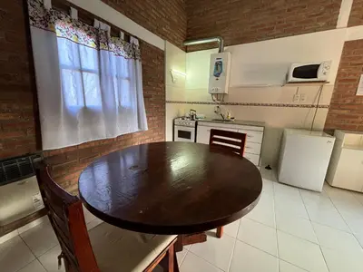 a kitchen with a wooden table in a kitchen at Departamentos Los Álamos in Mina Clavero