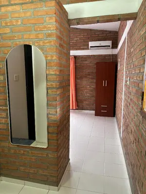 a bathroom with a mirror and a brick wall at Departamentos Los Álamos in Mina Clavero
