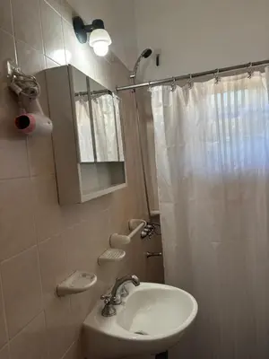a bathroom with a sink and a shower curtain at Departamentos Los Álamos in Mina Clavero