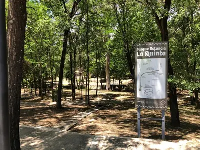 a sign in the middle of a park with trees at Departamento LA PAZ in Villa Carlos Paz