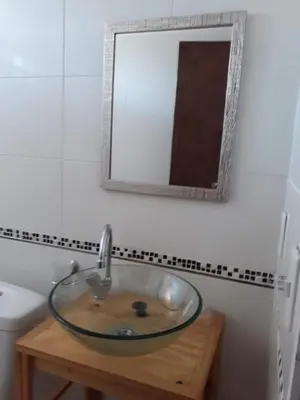 a glass sink in a bathroom with a mirror at Departamento LA PAZ in Villa Carlos Paz