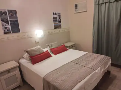 a bedroom with a large bed with two red pillows at Camino Real Hotel in Cordoba