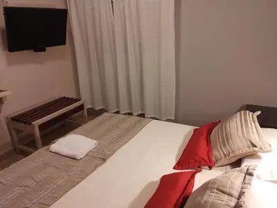 a bedroom with a bed with a television and a bench at Camino Real Hotel in Cordoba