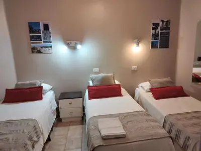 a bedroom with two twin beds with red pillows at Camino Real Hotel in Cordoba