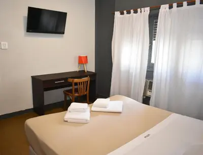 a bedroom with a desk and a bed with towels at Gran Rex Hotel in Cordoba