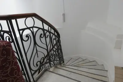 a staircase with a wrought iron railing and a stair case at Gran Rex Hotel in Cordoba