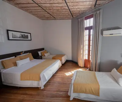 a bedroom with two beds and a window at Gran Rex Hotel in Cordoba
