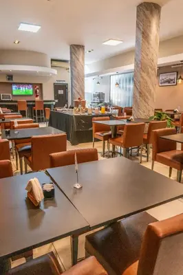 a restaurant with tables and chairs and a buffet at Hotel Everest in Cordoba