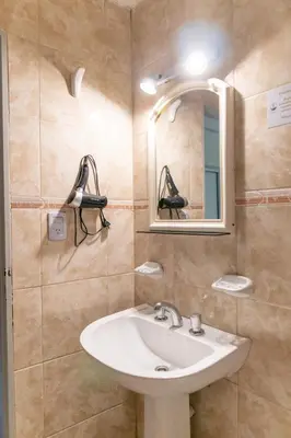 a bathroom with a sink and a mirror at Hotel Everest in Cordoba