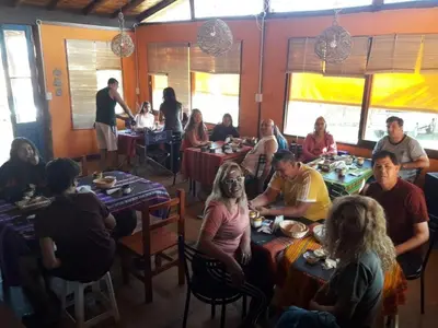 a group of people sitting at tables in a restaurant at Sierra Magenta in Los Hornillos