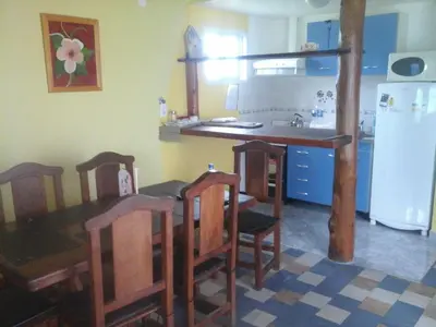 a kitchen with a table and chairs and a refrigerator at Sierra Magenta in Los Hornillos