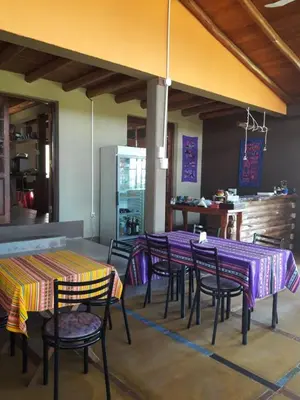 a restaurant with purple tables and chairs and a kitchen at Sierra Magenta in Los Hornillos