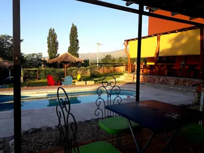 a table and chairs next to a swimming pool at Sierra Magenta in Los Hornillos