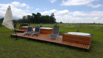 a deck with four chairs and an umbrella at Amatxi in Los Reartes