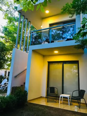 two chairs and a table in front of a house at BOULEVARD departamentos in Mina Clavero