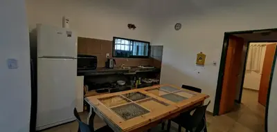 a kitchen with a table and a white refrigerator at Villa Elena Icho Cruz in Villa Icho Cruz