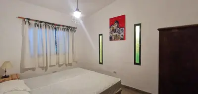 a bedroom with a bed and three windows at Villa Elena Icho Cruz in Villa Icho Cruz