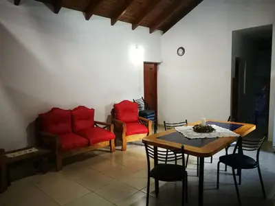 a living room with red furniture and a table and chairs at El Maná in Bialet Massé