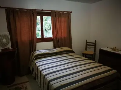 a bedroom with a striped bed in front of a window at El Maná in Bialet Massé