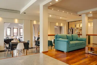 a living room with a blue couch and a dining room at Riviera Hotel & Spa in Villa Carlos Paz