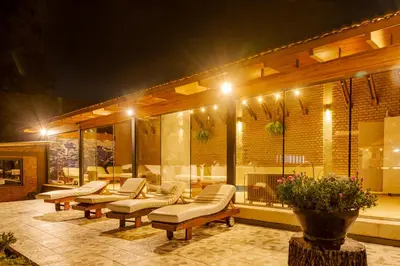 a patio with couches and chairs at night at Riviera Hotel & Spa in Villa Carlos Paz