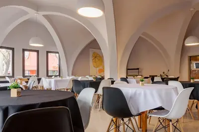 a dining room with white tables and chairs at Riviera Hotel & Spa in Villa Carlos Paz