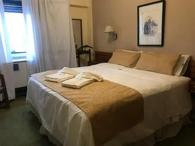 a bedroom with a bed with two towels on it at Hotel Sussex in Cordoba