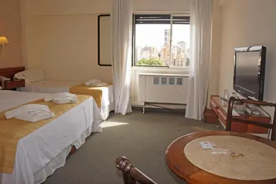 a hotel room with two beds and a window at Hotel Sussex in Cordoba