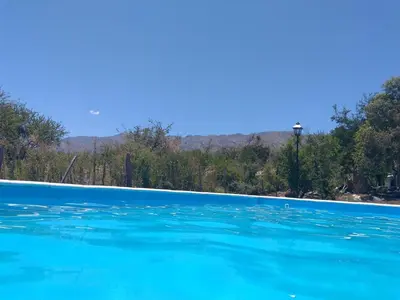 a pool of blue water with trees in the background at Antiguo Molle in Merlo