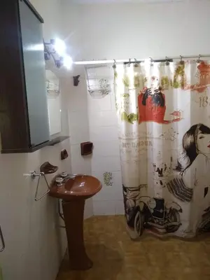 a bathroom with a shower curtain and a sink at Blacky House in Villa Carlos Paz