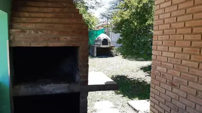 an outdoor brick oven in a yard next to a brick wall at Blacky House in Villa Carlos Paz