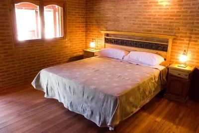 a bedroom with a bed with two night stands and two lamps at Lauquen Pilmaiquen y spa in Merlo